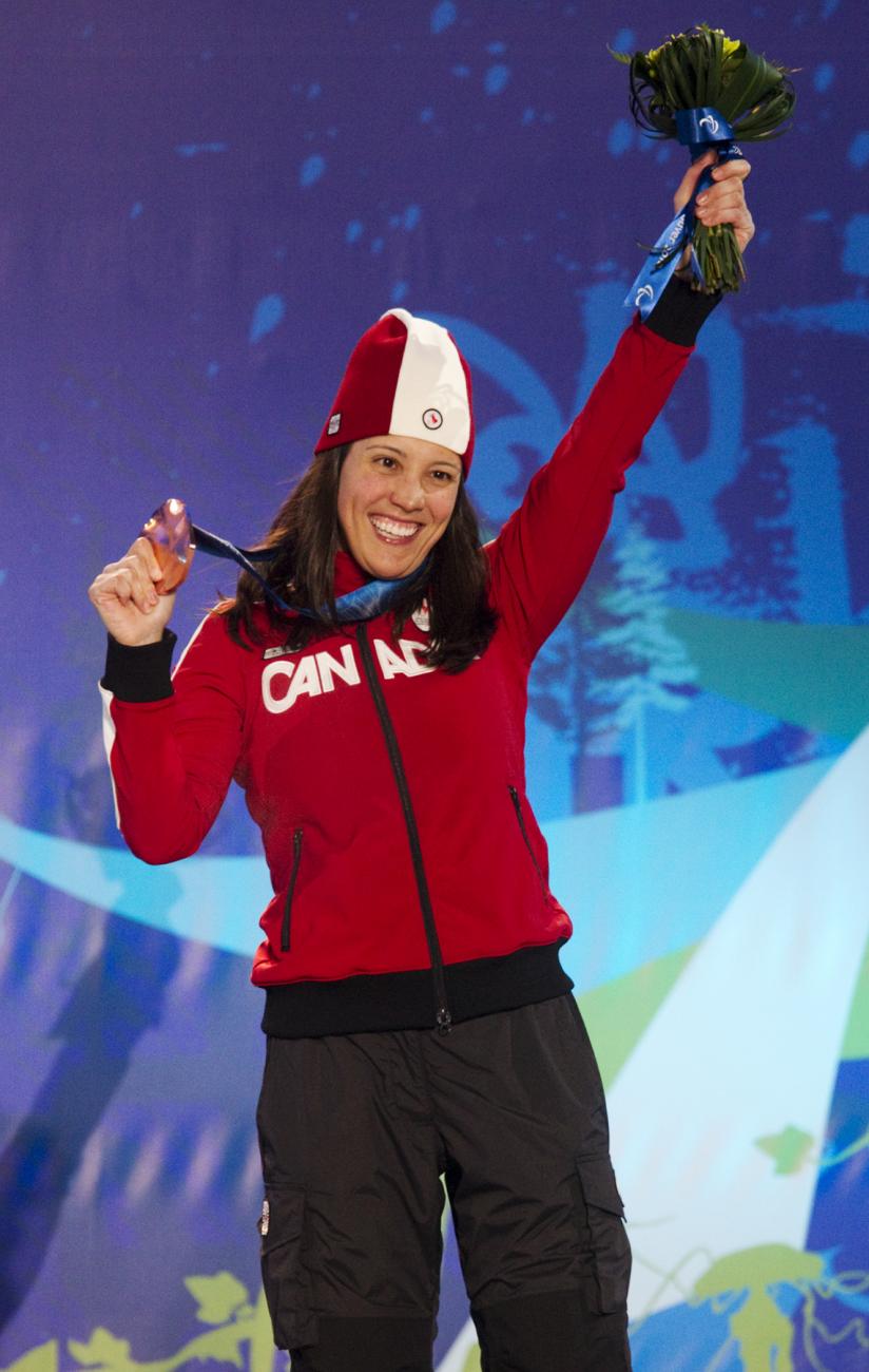 Karolina Wisniewska, dotée d'une veste rouge et d'un chapeau du Canada, brandit une médaille.