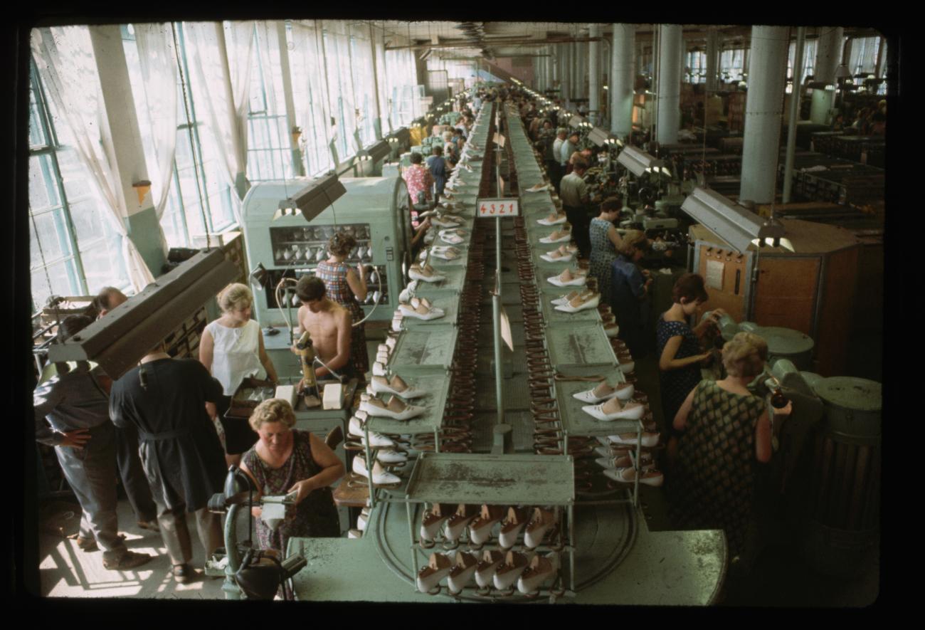 Des rangées de femmes travaillent à la fabrication de chaussures.