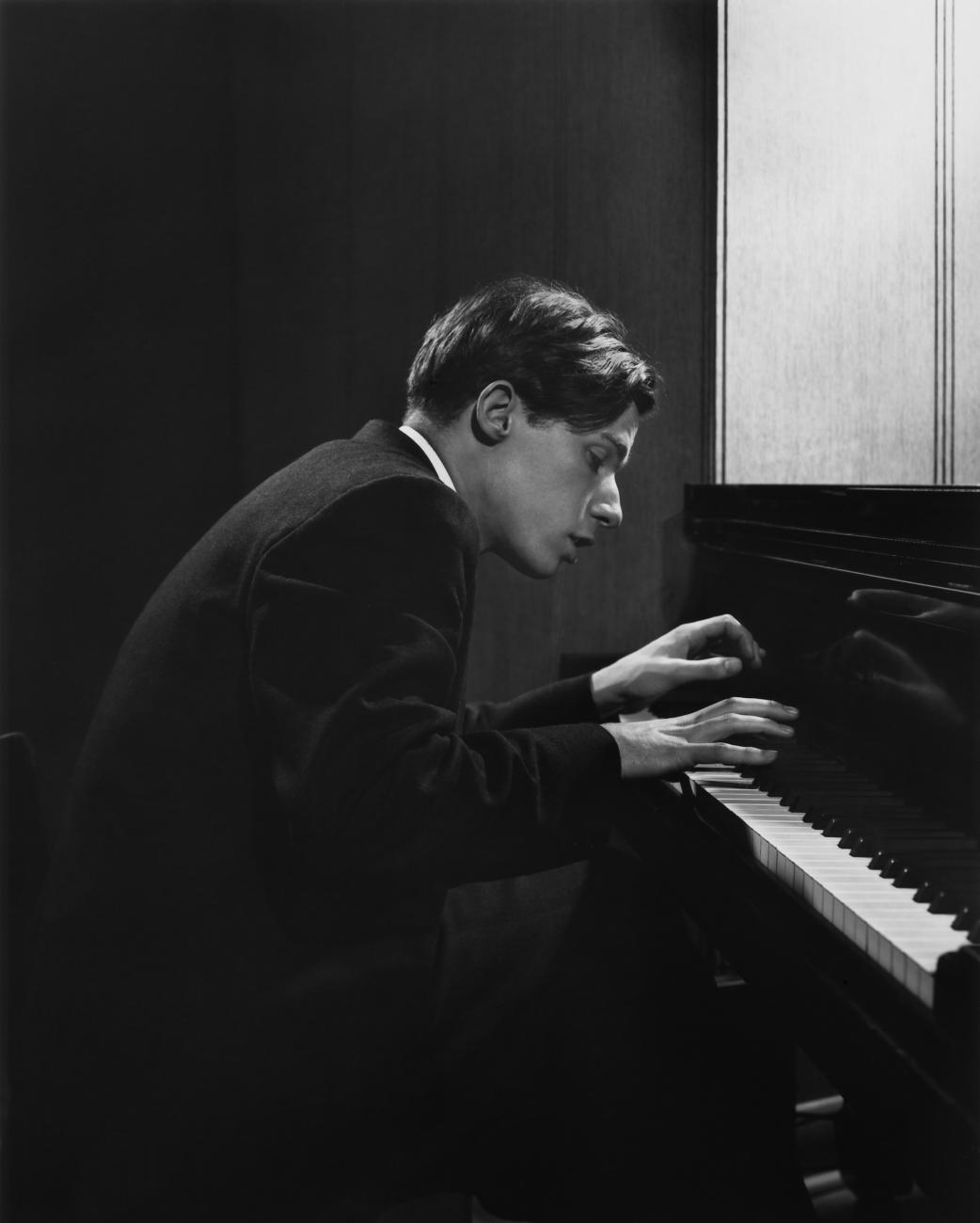 Photo en noir et blanc d’un homme jouant du piano.