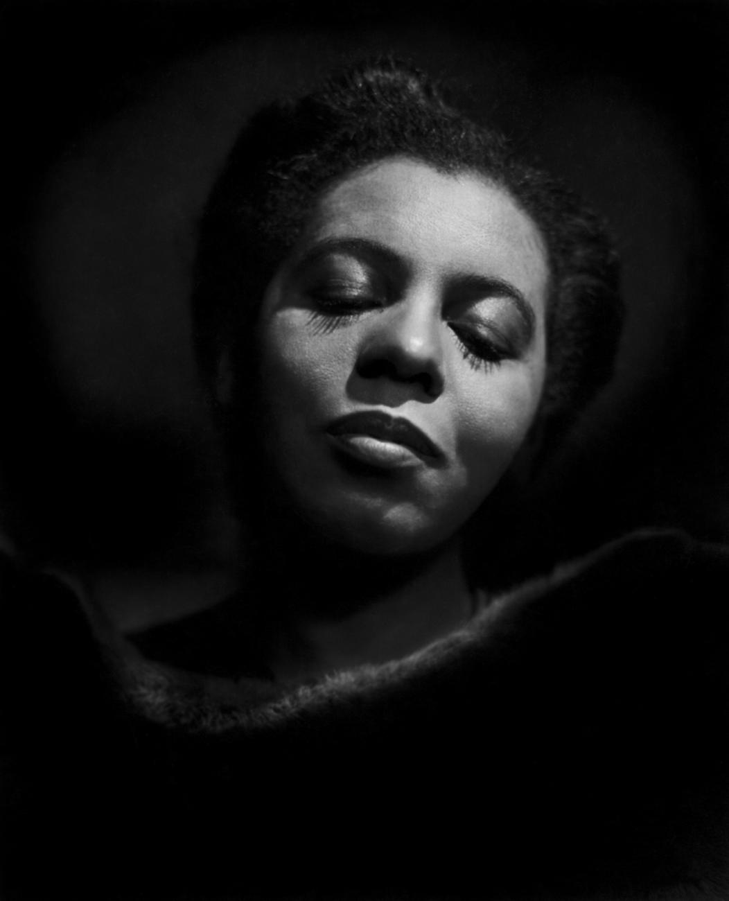 Portrait en noir et blanc d’une femme aux yeux fermés.