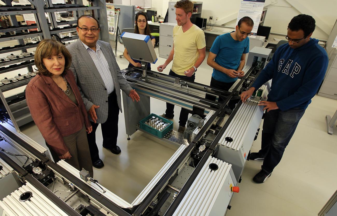 Hoda et Waguih ElMaraghy debout avec quatre autres personnes dans un laboratoire d’ingénierie.