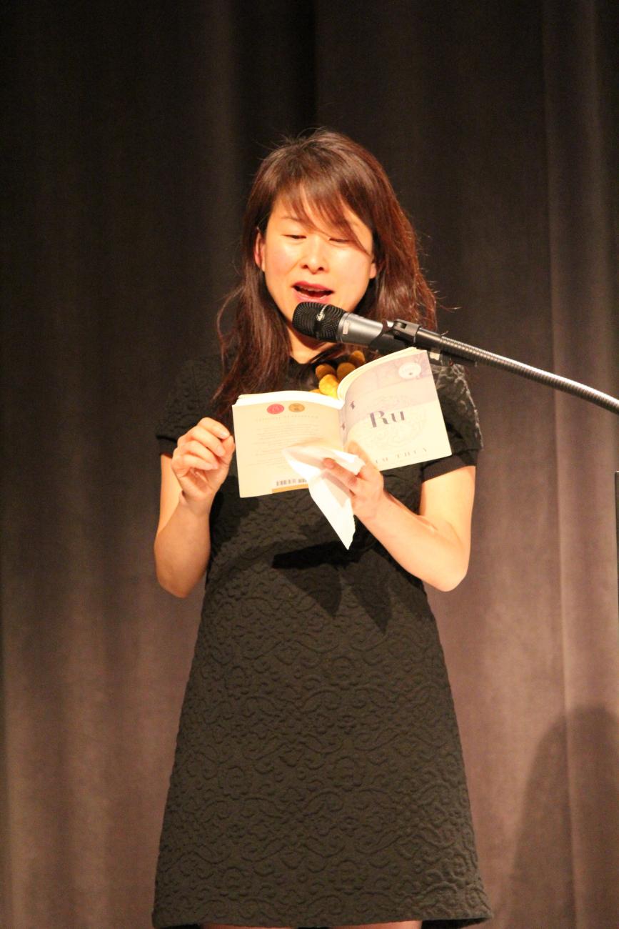 Kim Thuy lit un extrait de son livre sur scène.
