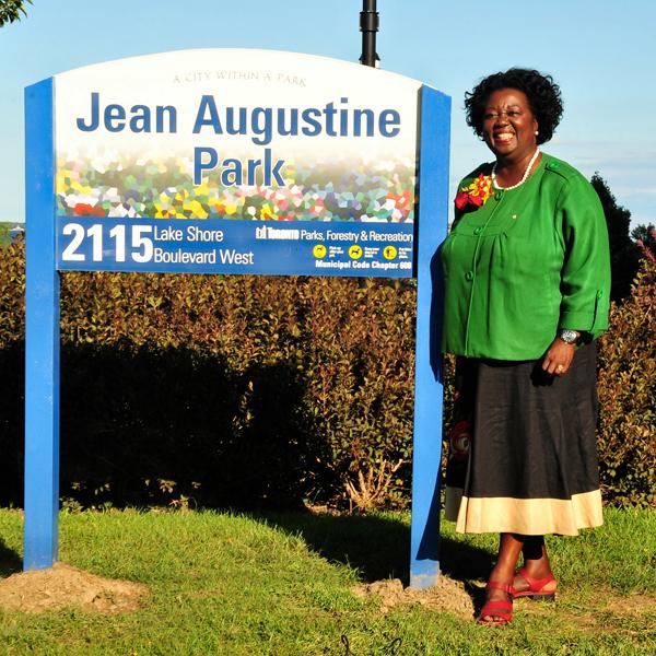 Jean Augustine se tient près d’un panneau indiquant le parc Jean Augustine.