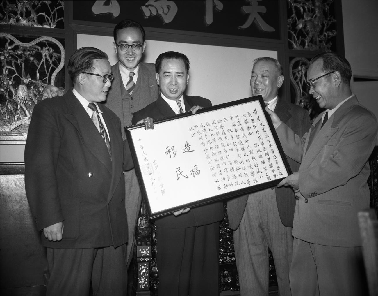 Wong Foon Sien et quatre autres hommes tenant un texte encadré de caractères chinois.