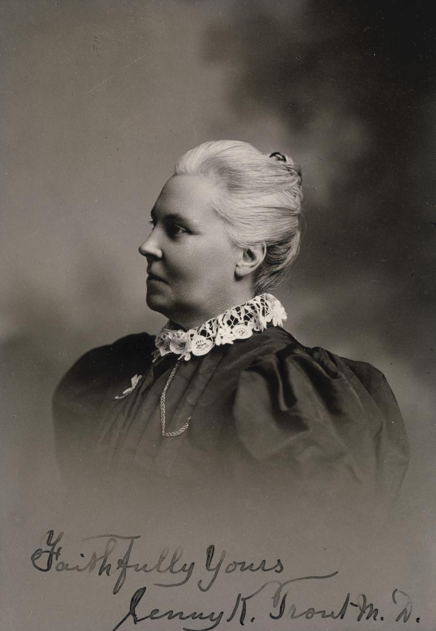 Portrait en noir et blanc de la tête et des épaules de Jennie Trout en robe sombre avec un haut col de dentelle.